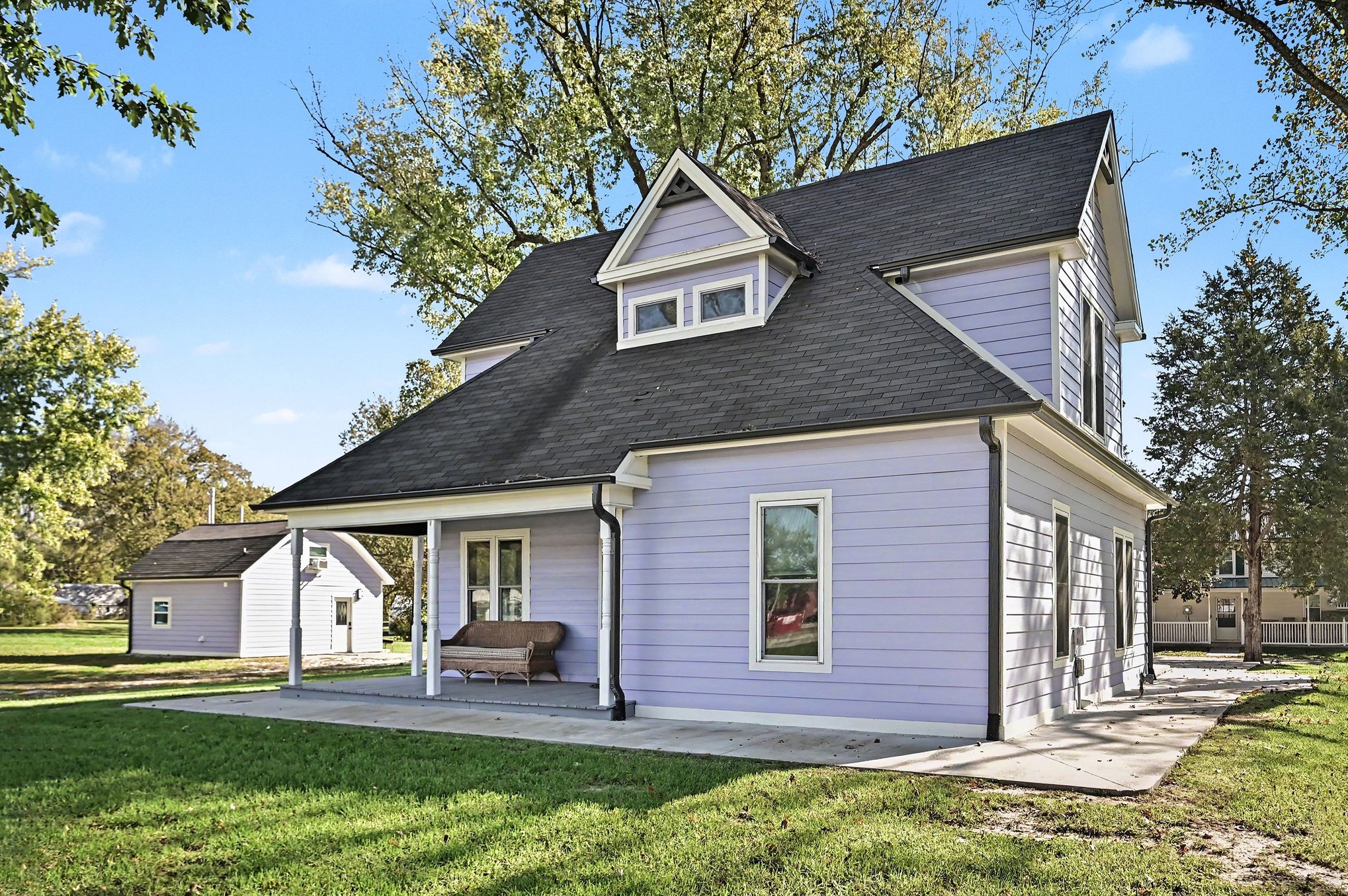 Side view of the farmhouse with porch and detached guest house beyond