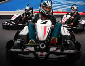 alt="Indoor go-karts racing on the track at K1 Speed, a premier family entertainment destination in Jessup, MD."