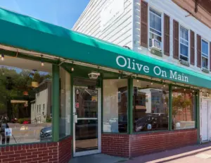 alt="The charming and historic storefront of Olive on Main, a popular Mediterranean restaurant on Main Street in Laurel, MD."