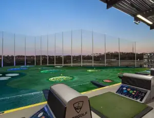 alt="A view of the high-tech driving bays at Topgolf, a popular entertainment destination in Germantown, MD."