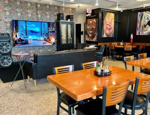 alt="The welcoming storefront of the New Deal Café, a historic cooperative restaurant and music venue in Greenbelt, MD."