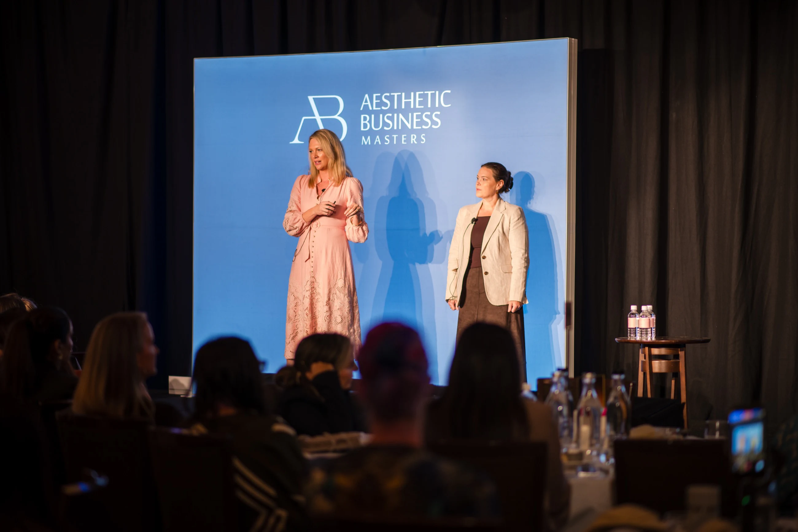 Kelly Wotherspoon and Alicia Hagen teaching a room of clinic owners