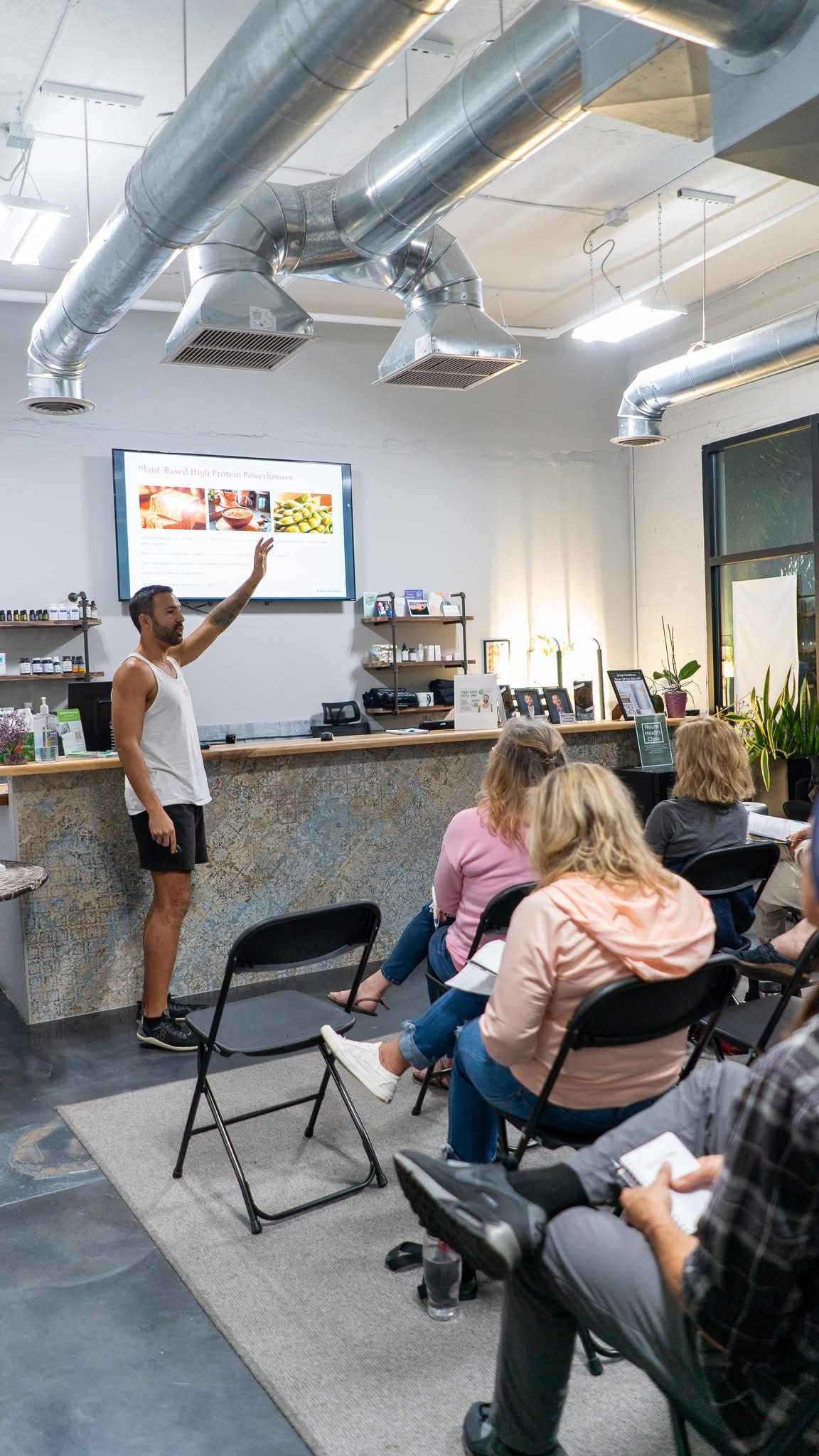 Bryan pointing to a meal slide while teaching a nutrition workshop to a seated group