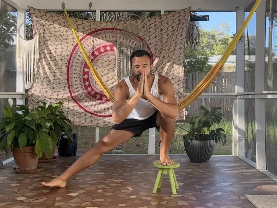 Bryan doing a modified side squat at home, one foot on a small stool