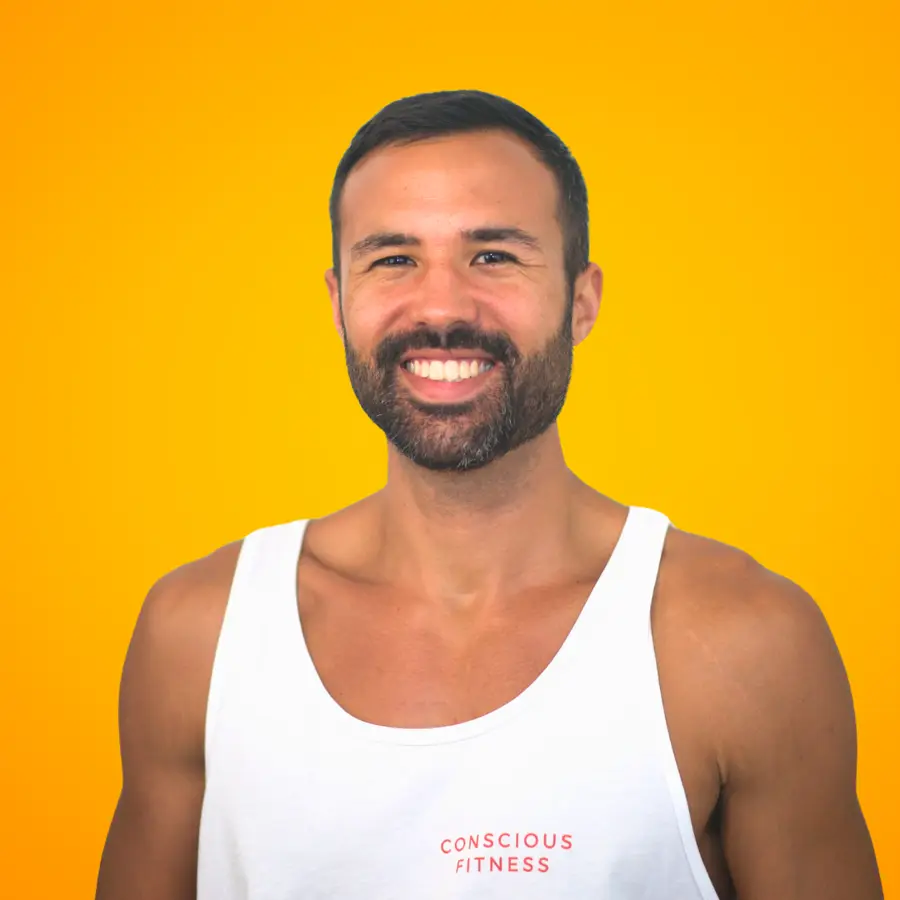 Vegan fitness coach Bryan Bell smiling in a Conscious Fitness tank top