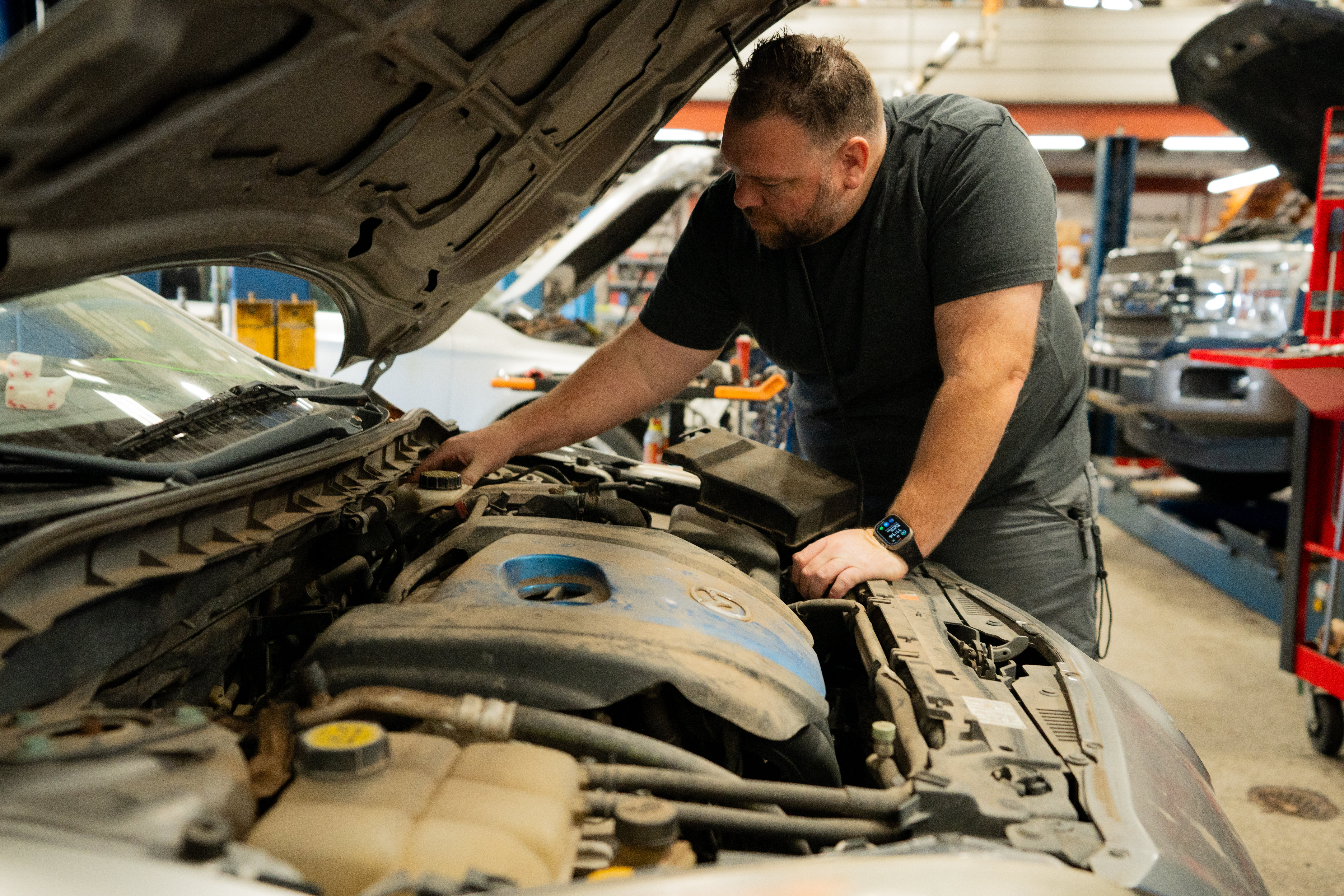 Technician inspecting an engine in a repair shop