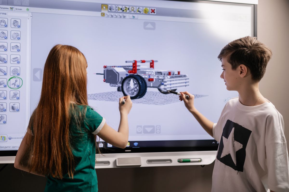 Students designing a LEGO-style robot on a smartboard