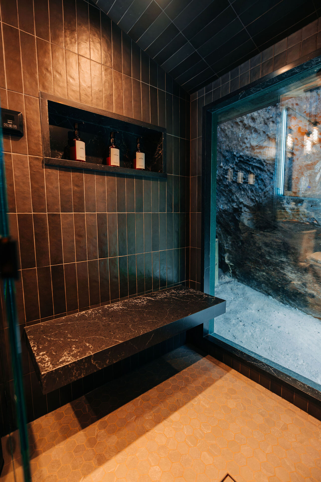 Dark-tiled steam shower with bench at Rockface Retreat