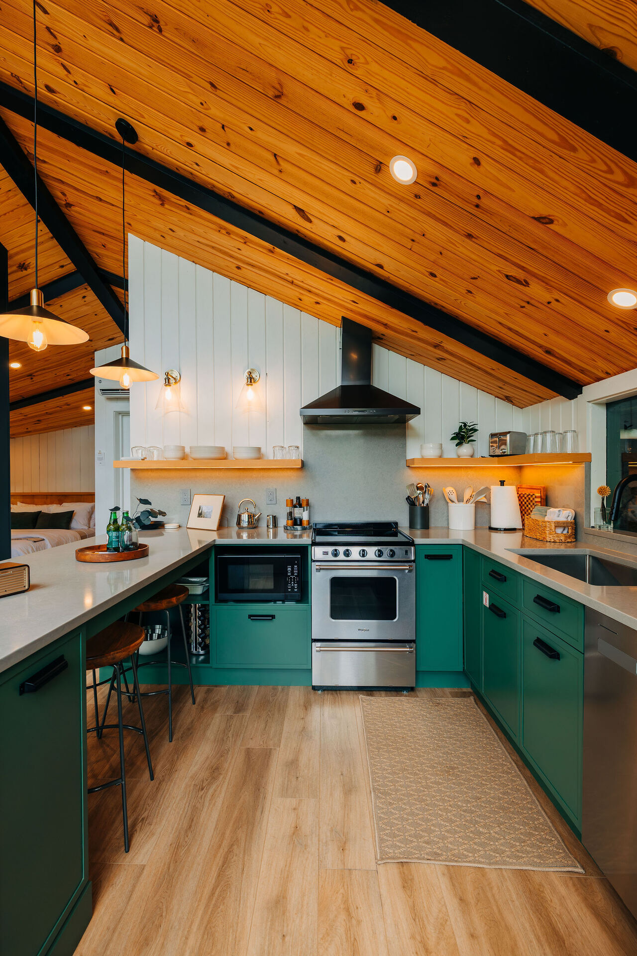 Green kitchen under a warm wood ceiling at Rockface Retreat