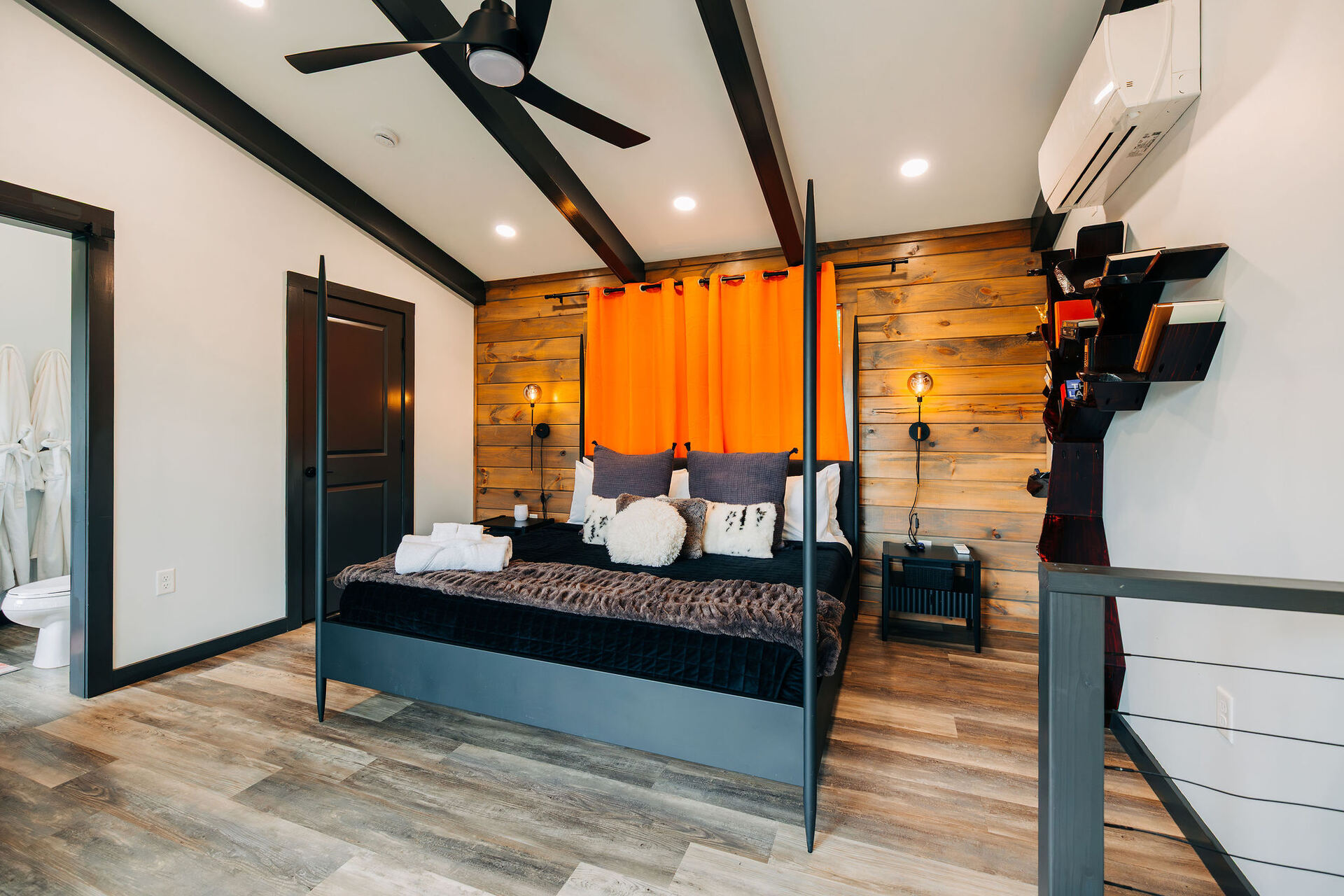 Bedroom at The Onyx with black walls and orange drapes