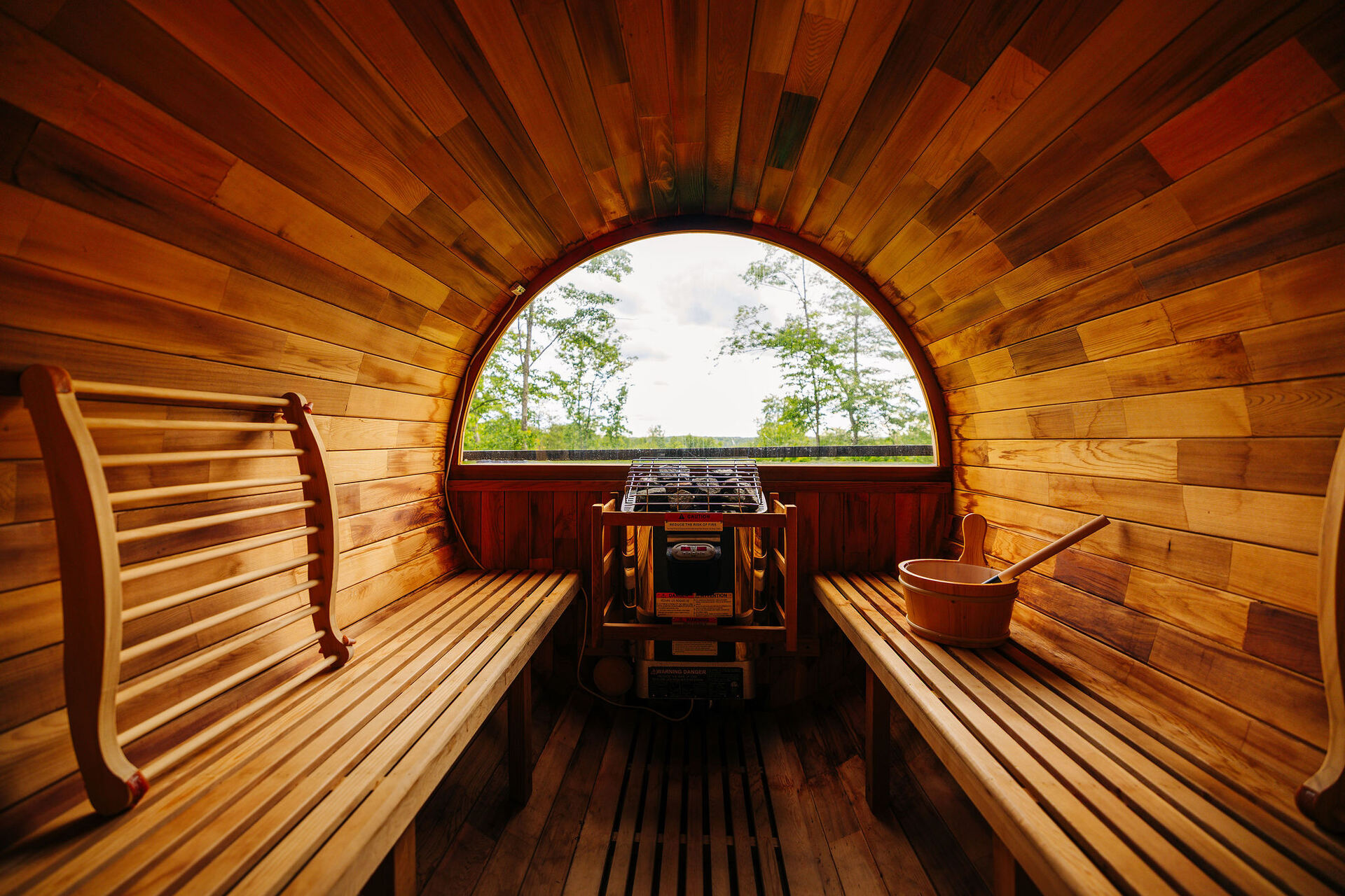 Inside the barrel sauna at The Onyx, forest visible through the round window