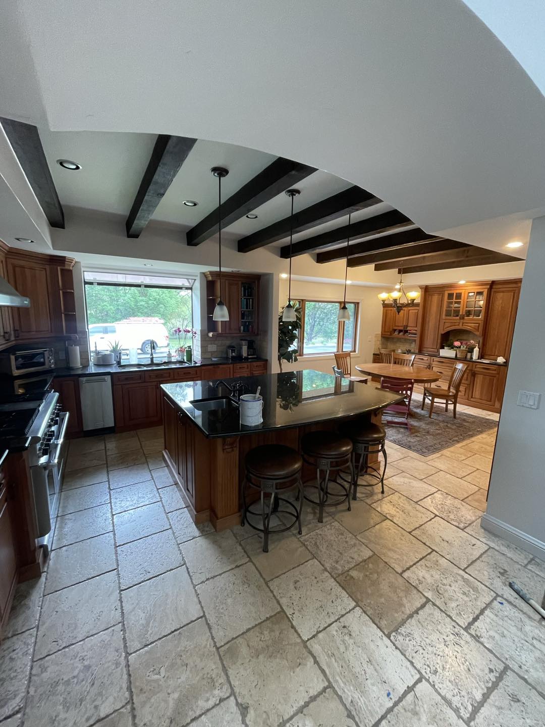 interior residential paint job in a kitchen with wood beams and stained cabinets