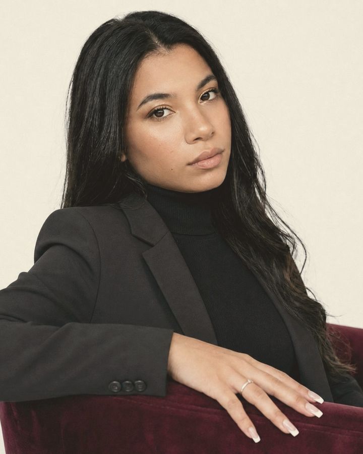 Shireen, founder of Trajectory Media, sitting in a red armchair