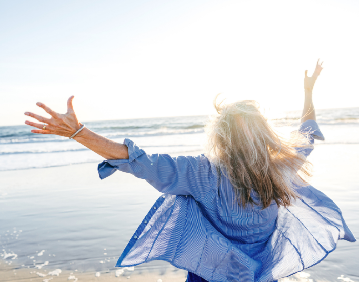 Woman happy looking at ocean because she revolutionized her life!