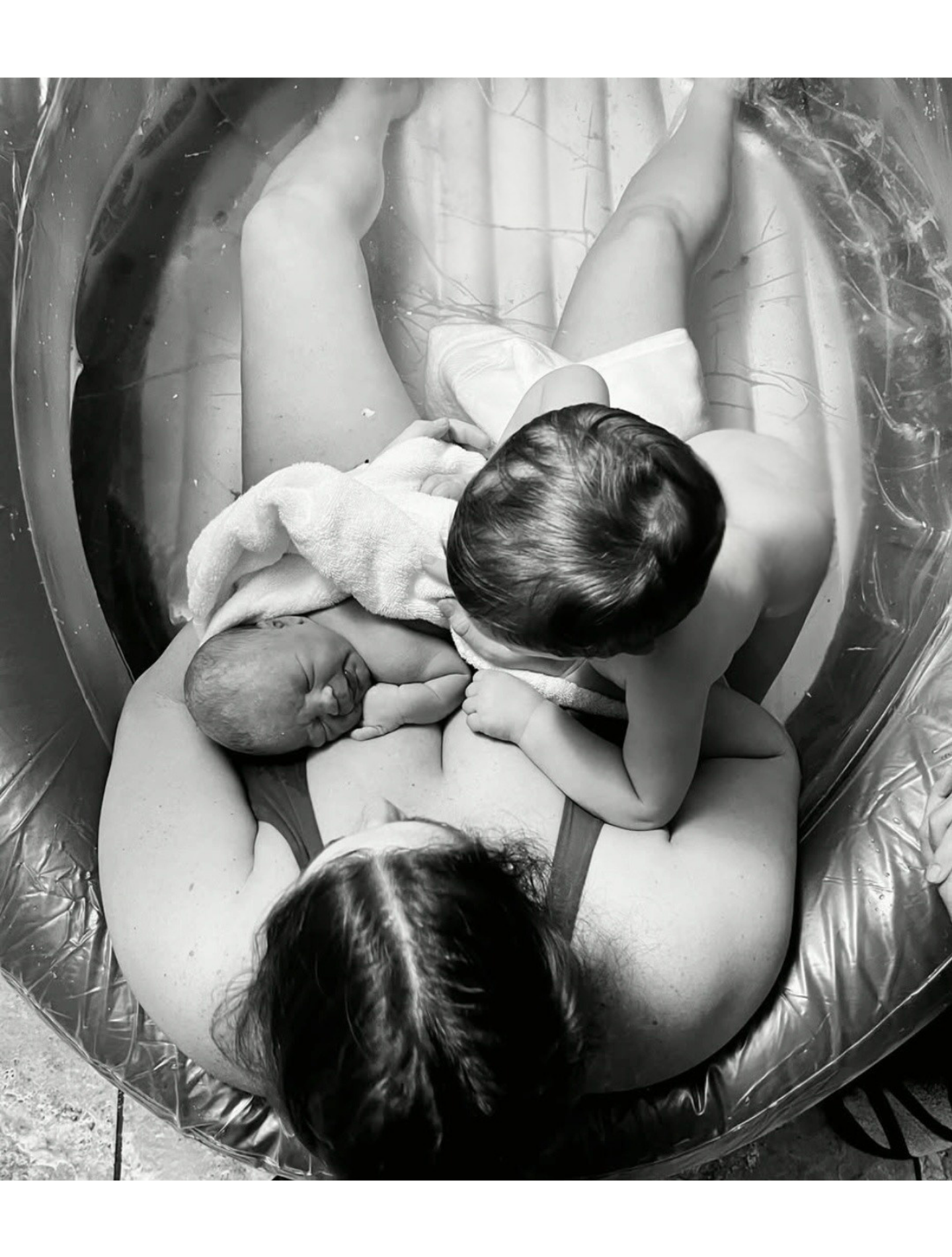 Water birth with mother and her toddler son in the tub