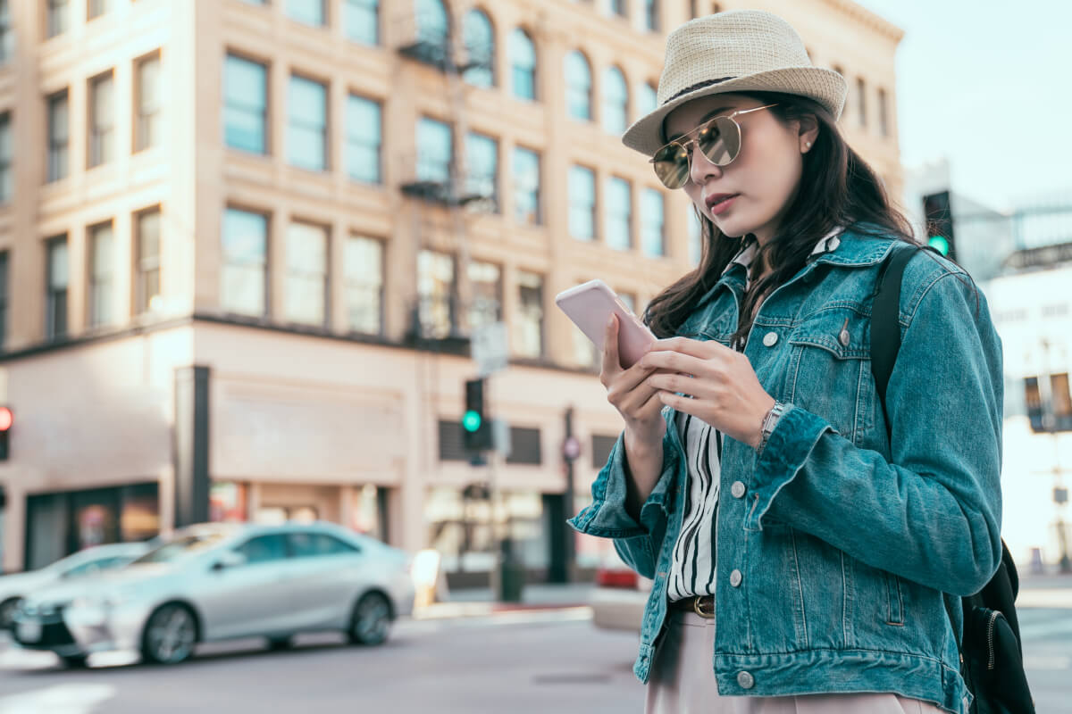 Woman on a downtown street searching on her phone