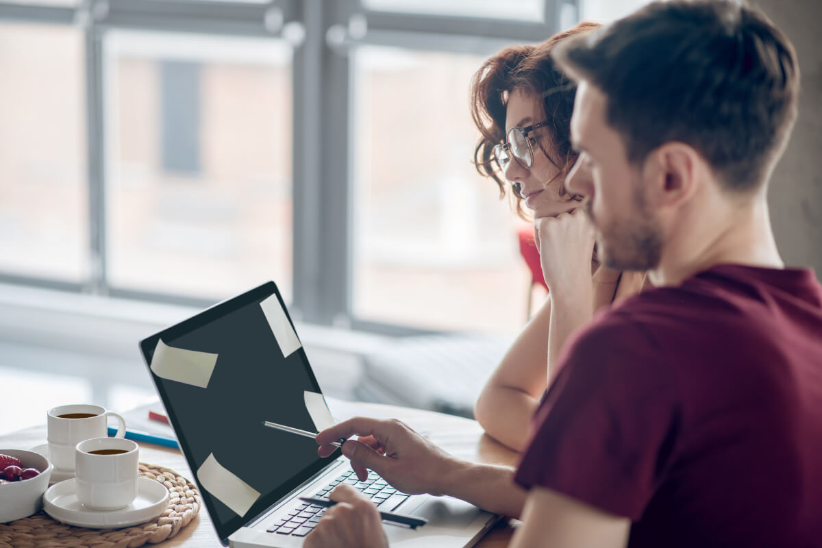 A business owner and a colleague reviewing the first build together on a laptop