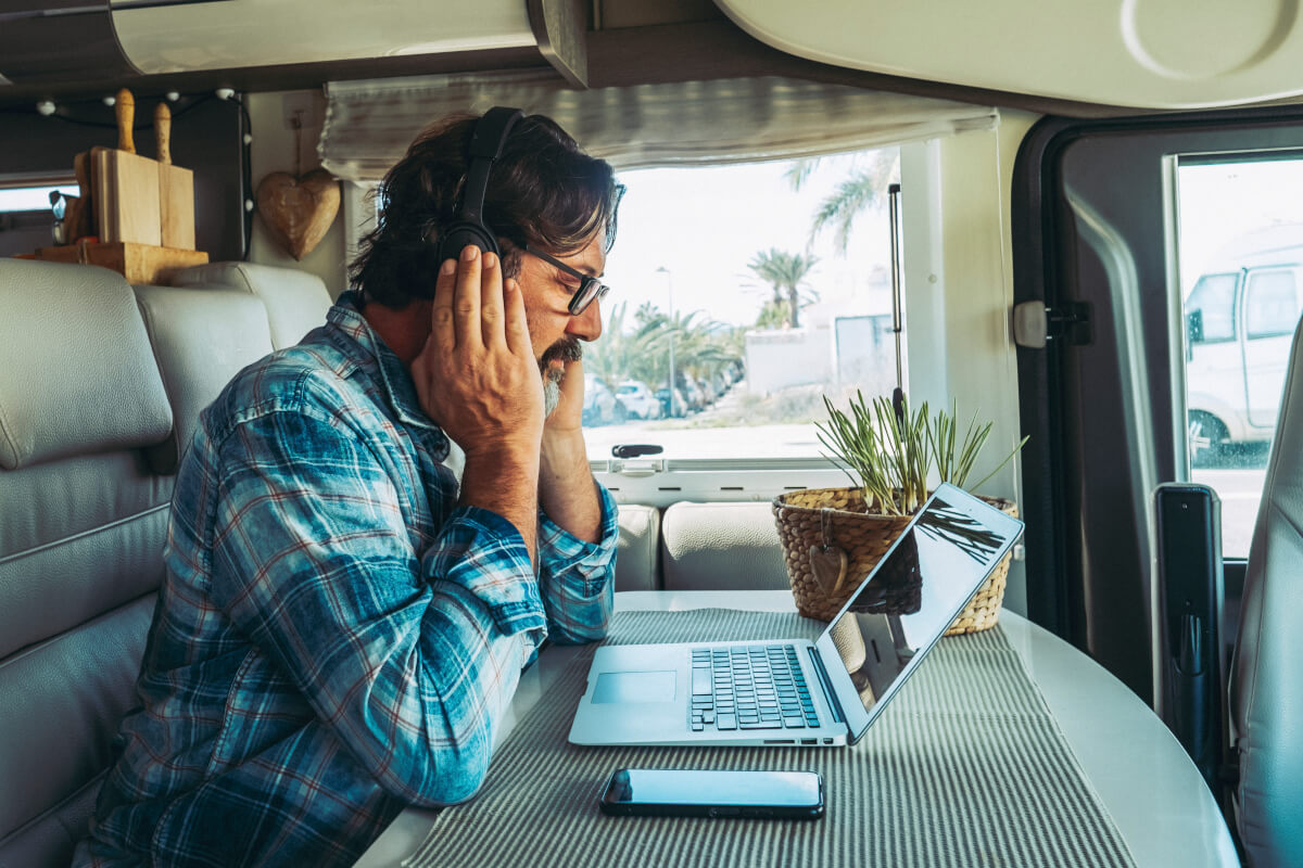 Small-business owner in the back of his work van, head in hand, staring at a laptop