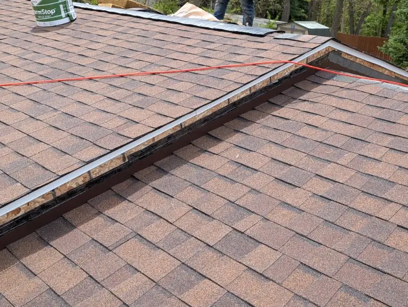 Close-up of neatly installed roof shingles and flashing detail by Mueller Construction
