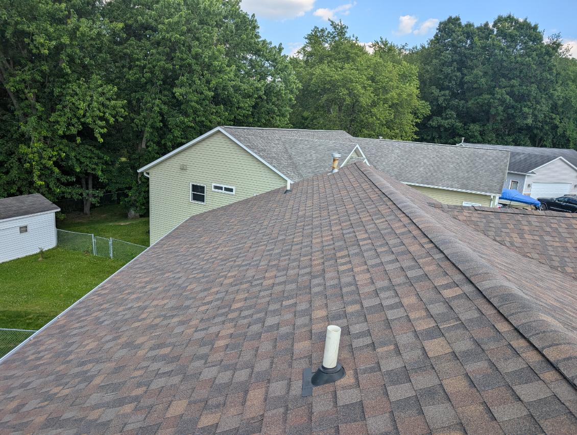 Completed residential roof with architectural shingles installed by Mueller Construction