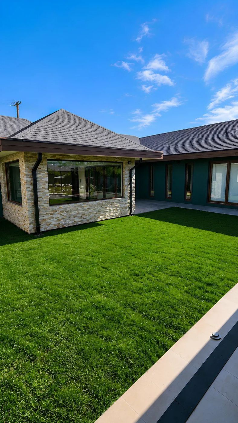 Casa de un nivel en Lomas de San Sebastián con revestimiento de piedra, grandes ventanales y patio de pasto