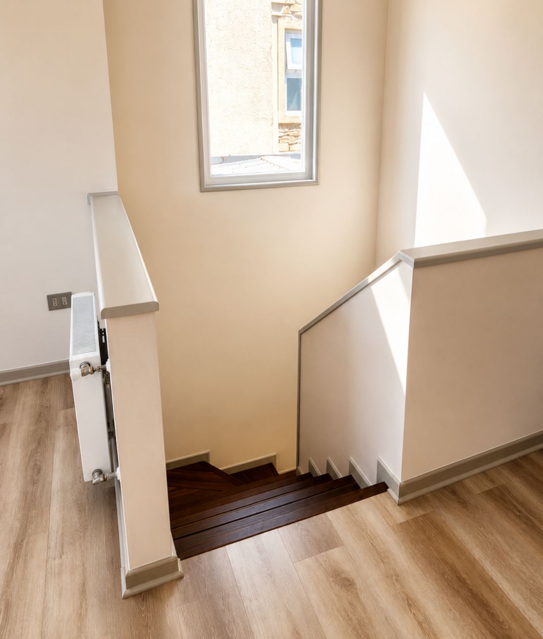 Caja de escala reconstruida con peldaños de madera, baranda y radiador