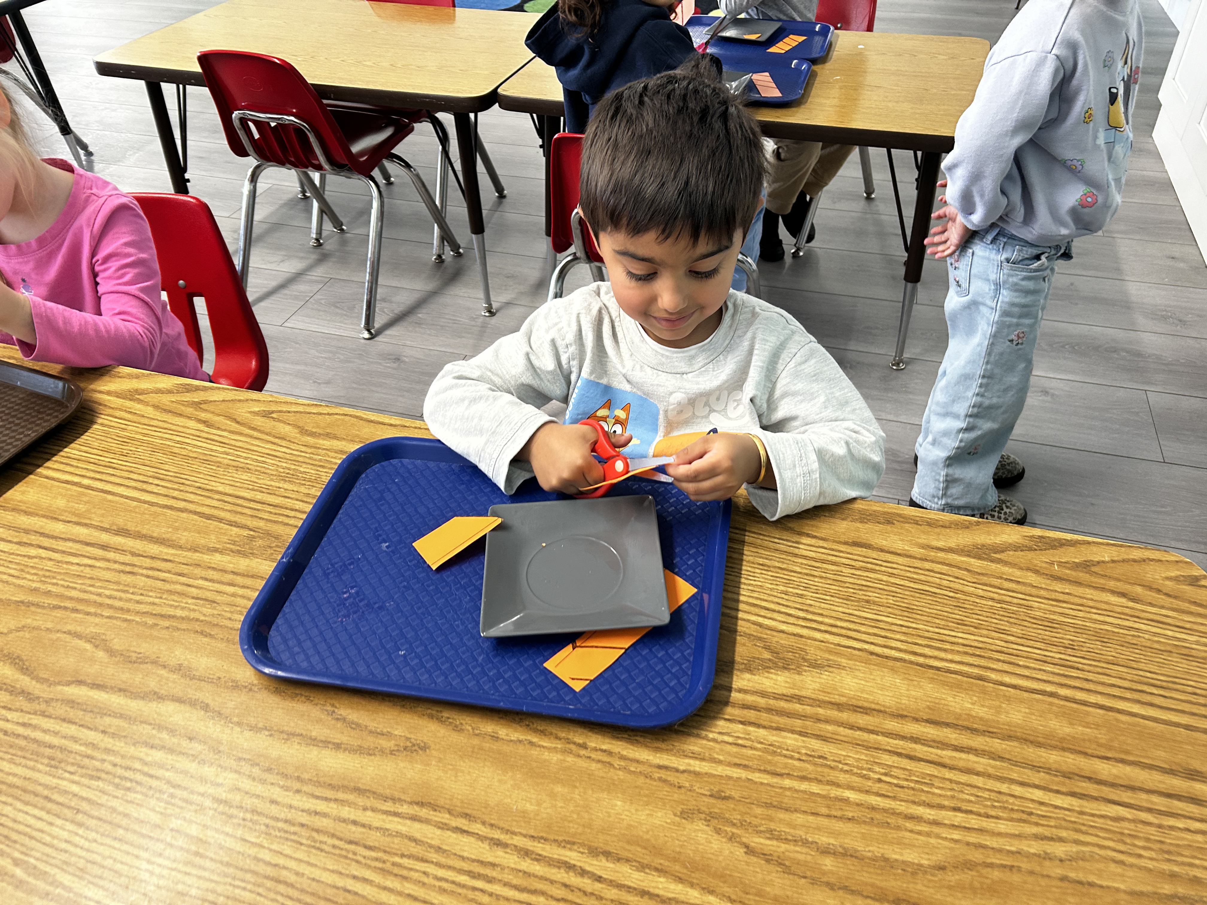Preschool child pouring water in a Montessori activity