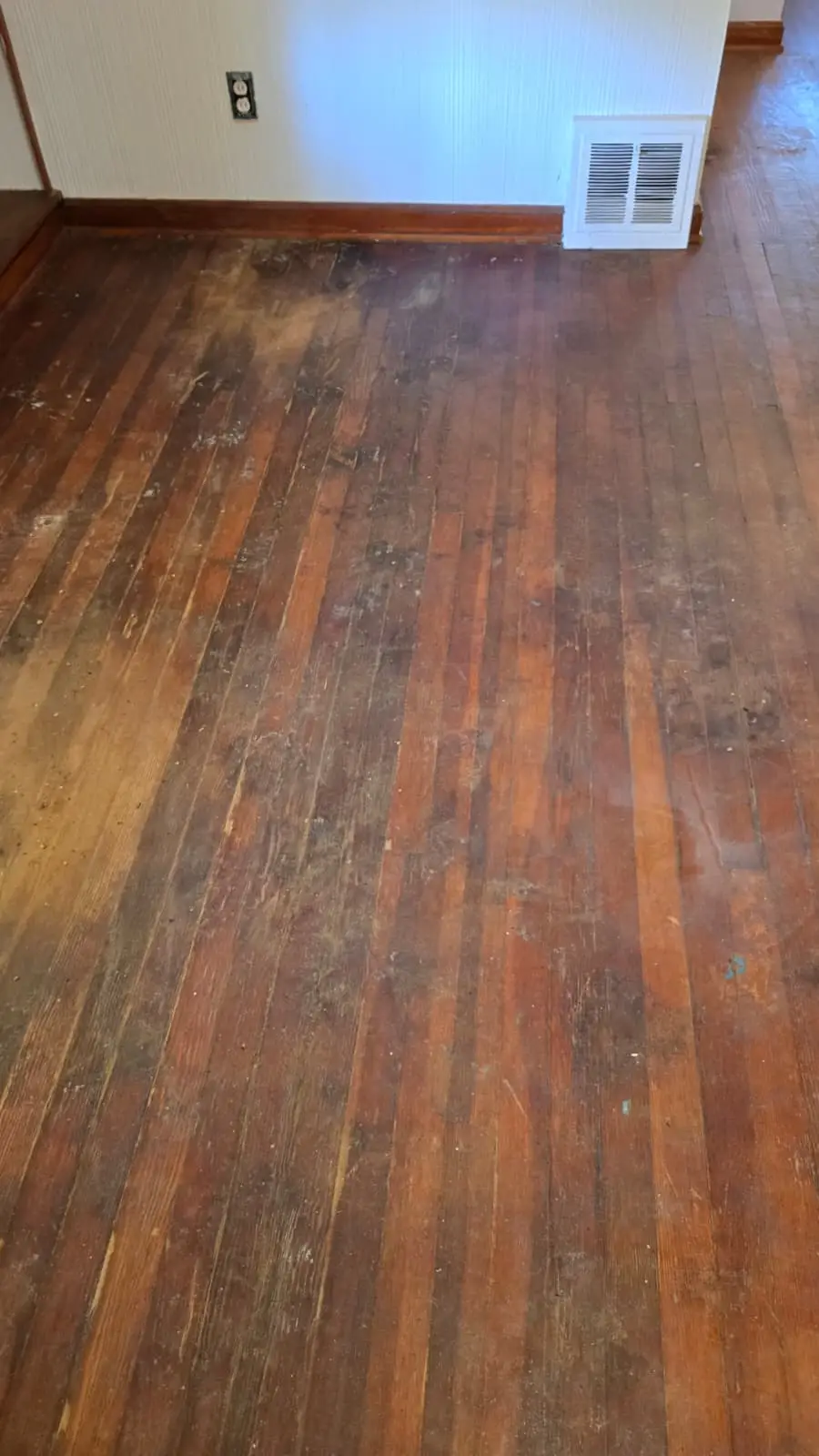 Worn hardwood floor before repair