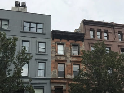 Renovated multi-story building facade in Queens, showing updated masonry and modern windows