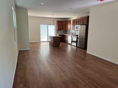 Newly painted kitchen in Queens featuring brown cabinetry, stainless steel appliances, and an open layout.