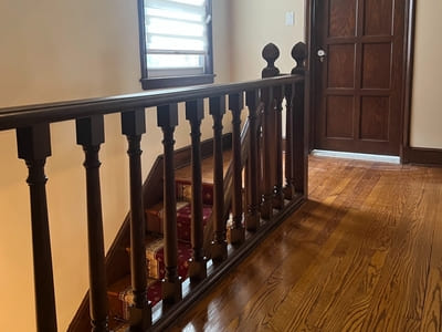 Beautifully crafted wooden staircase and hallway with dark wood doors in a residential home.