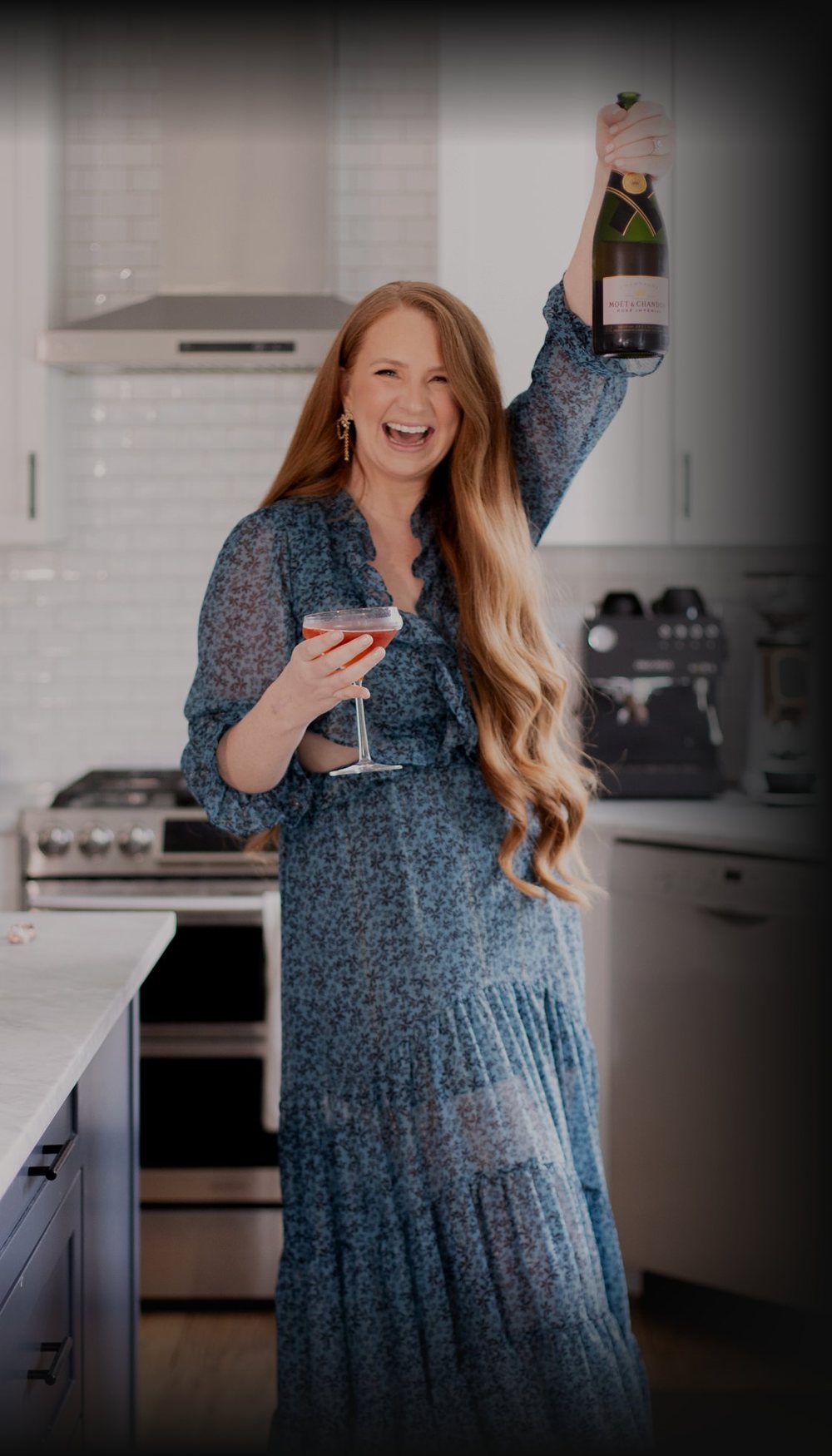 Kristina laughing, raising a bottle of champagne