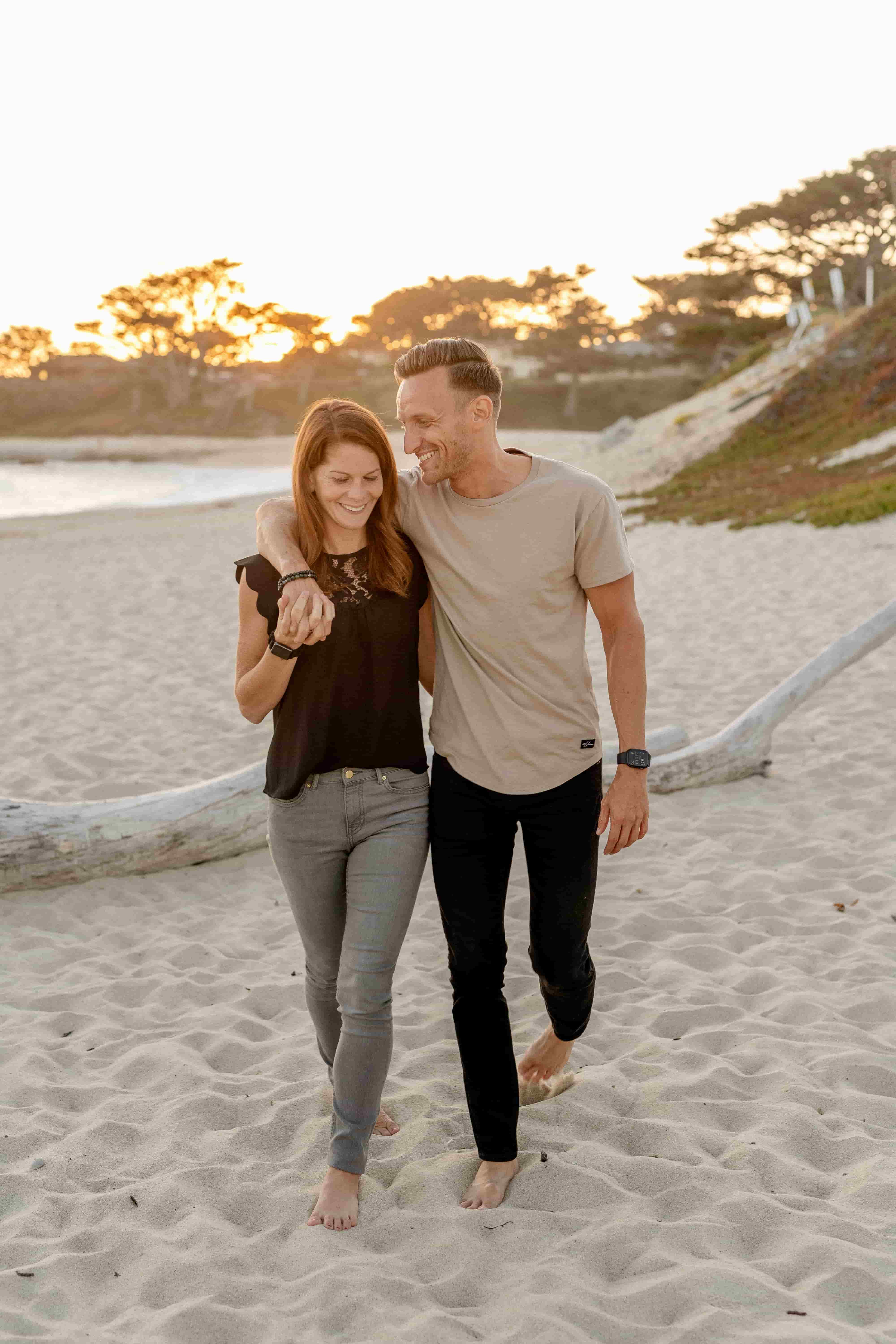 Couple walking on the beach arm in arm