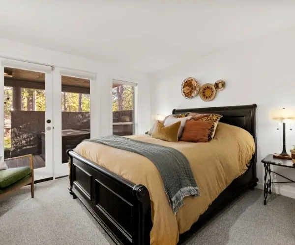 Luxury basement ADU conversion in Bend, OR, featuring a private exterior entrance, guest bedroom, and walk-out access to a hot tub. Example of a high-end secondary living suite or vacation rental remodel.