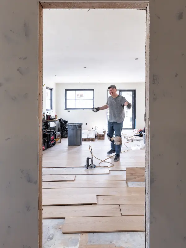 Modern front entry remodel in Sunriver, Oregon, with a custom wood entry door and new light hardwood flooring. Professional full-home renovation and interior designing in the Deschutes County.