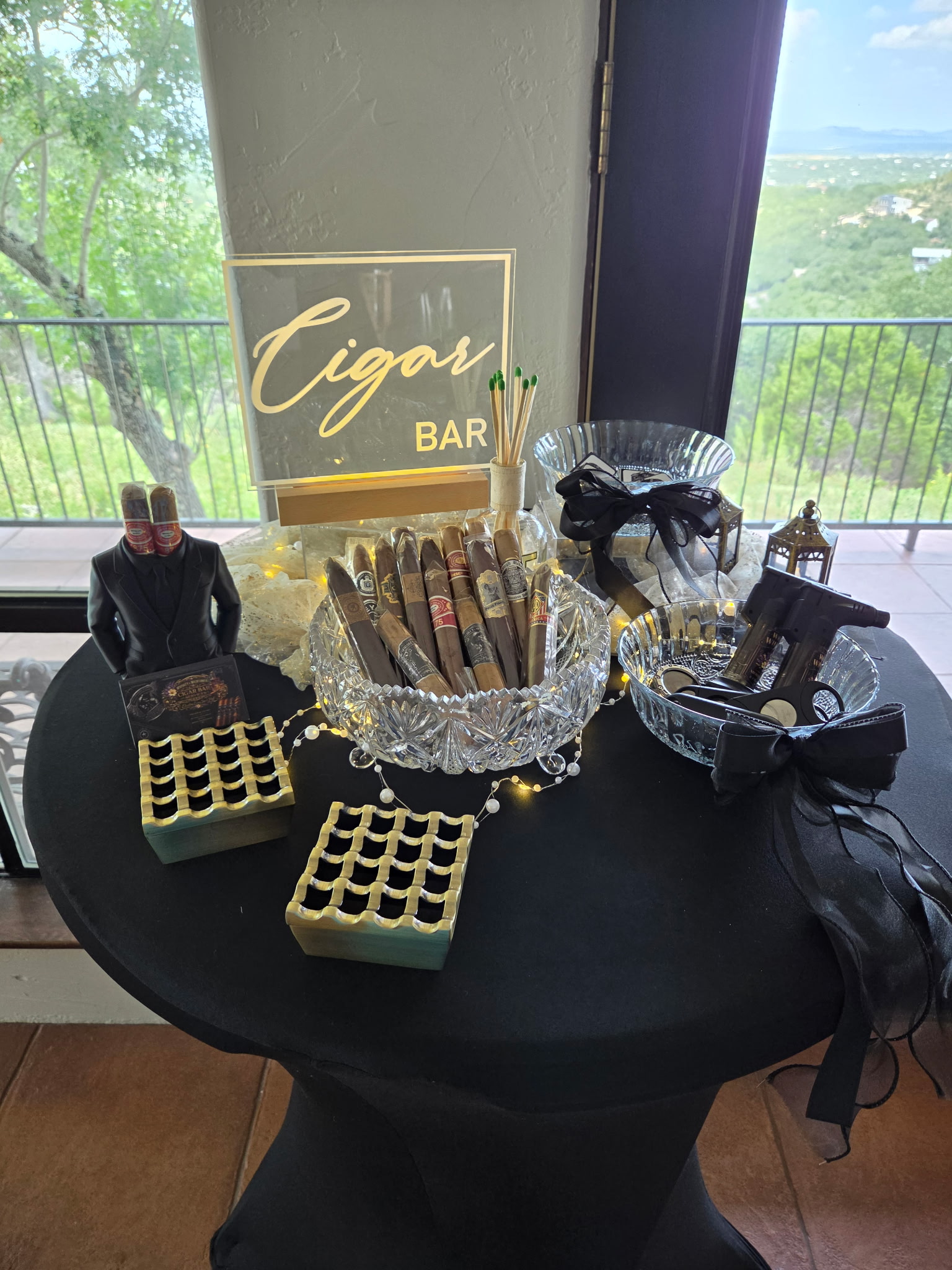 Illuminated Cigar Bar sign with cigars in a crystal bowl and gold favor boxes on a display table