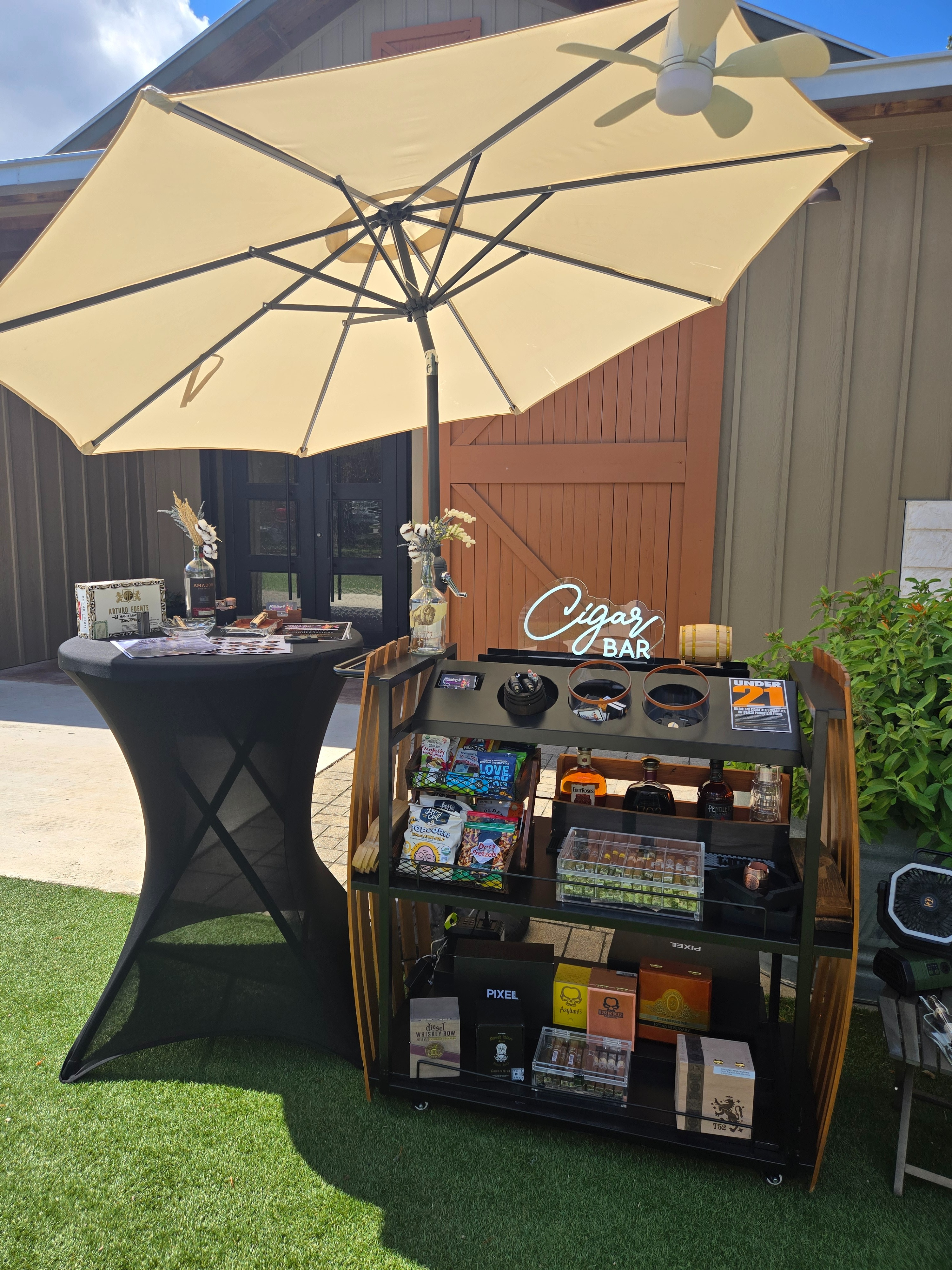 Wildflower cigar cart with neon sign and umbrella