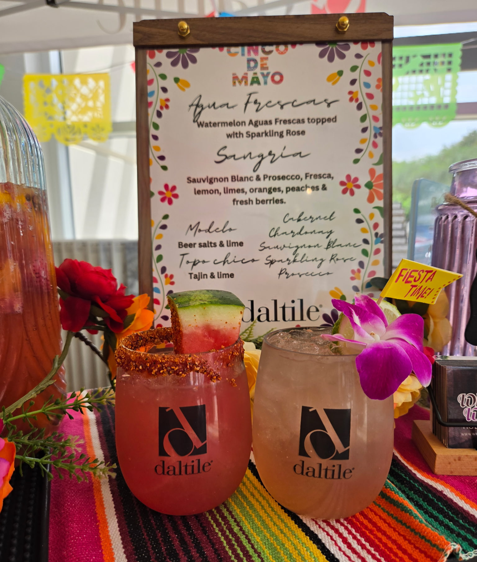 Two branded cocktails with a printed Cinco de Mayo specialty menu sign at a corporate event