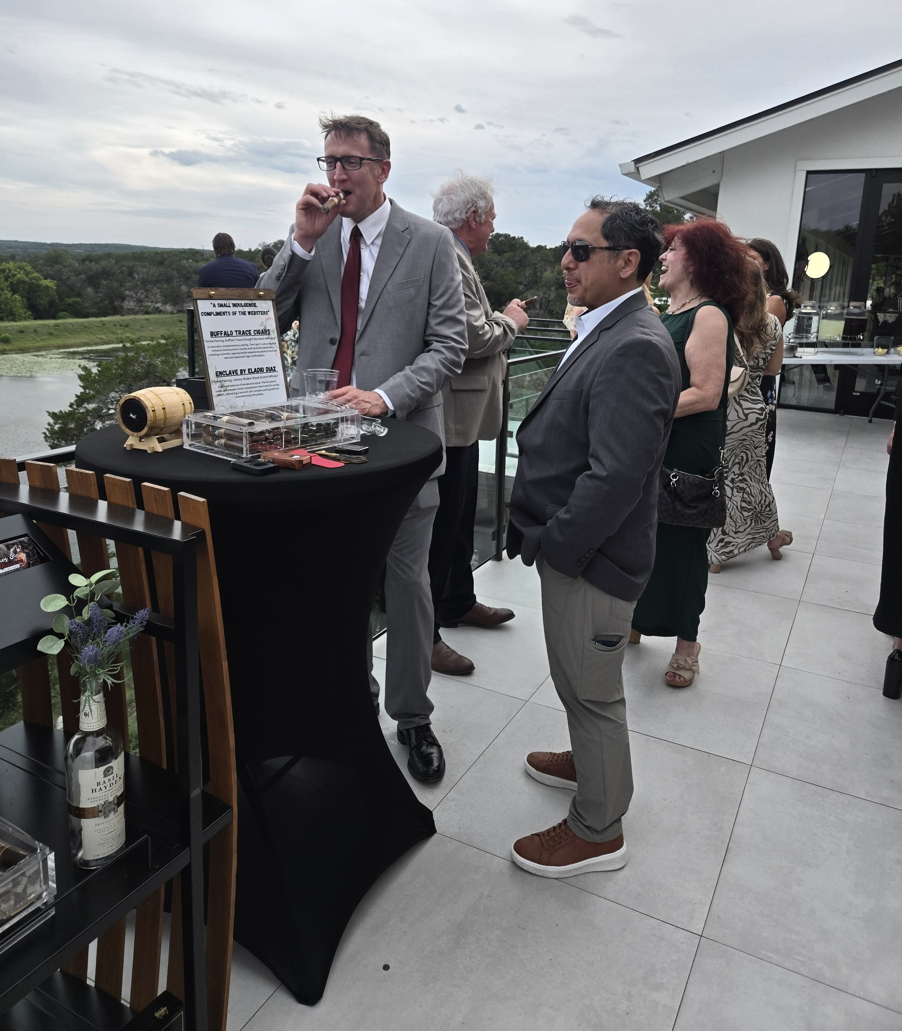 Guests gathered around a cigar display on a rooftop terrace overlooking the Hill Country