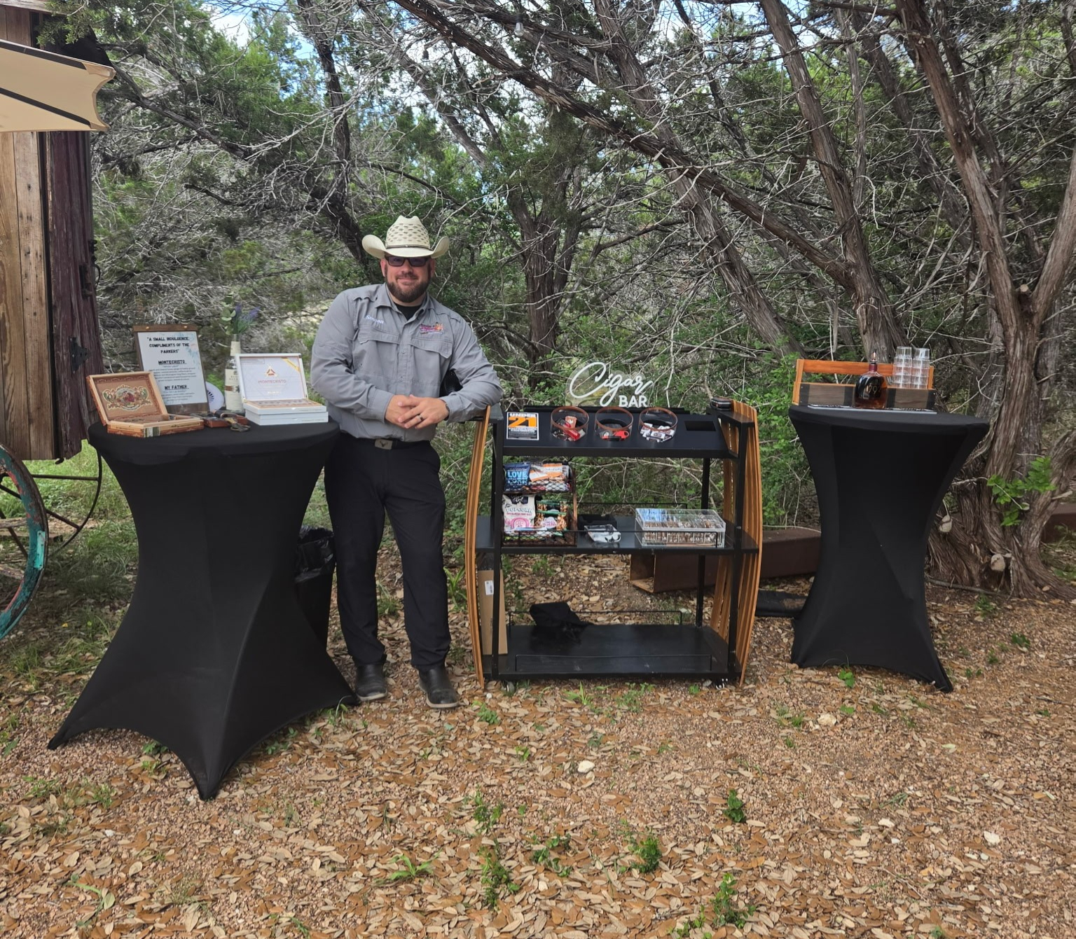 Cigar cart setup with attendant between cocktail tables at an outdoor venue