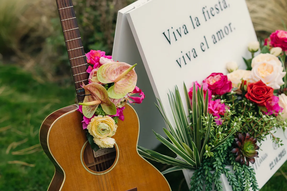 Gitarre mit Blumen neben dem Willkommensschild «Viva la fiesta, viva el amor»