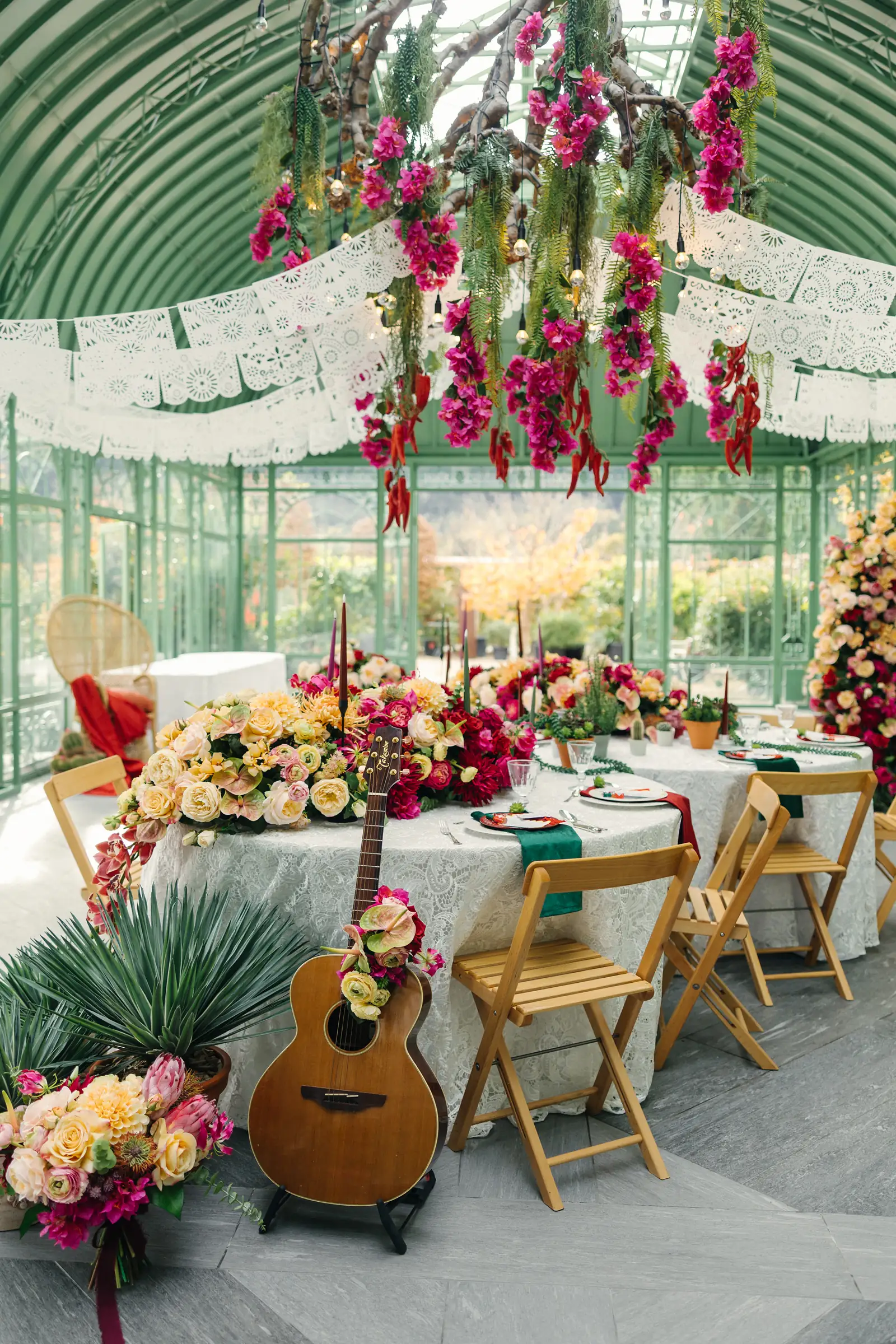 Festlich gedeckte Hochzeitstafel unter hängenden Blumen in der Orangerie des Gartenateliers Domat/Ems