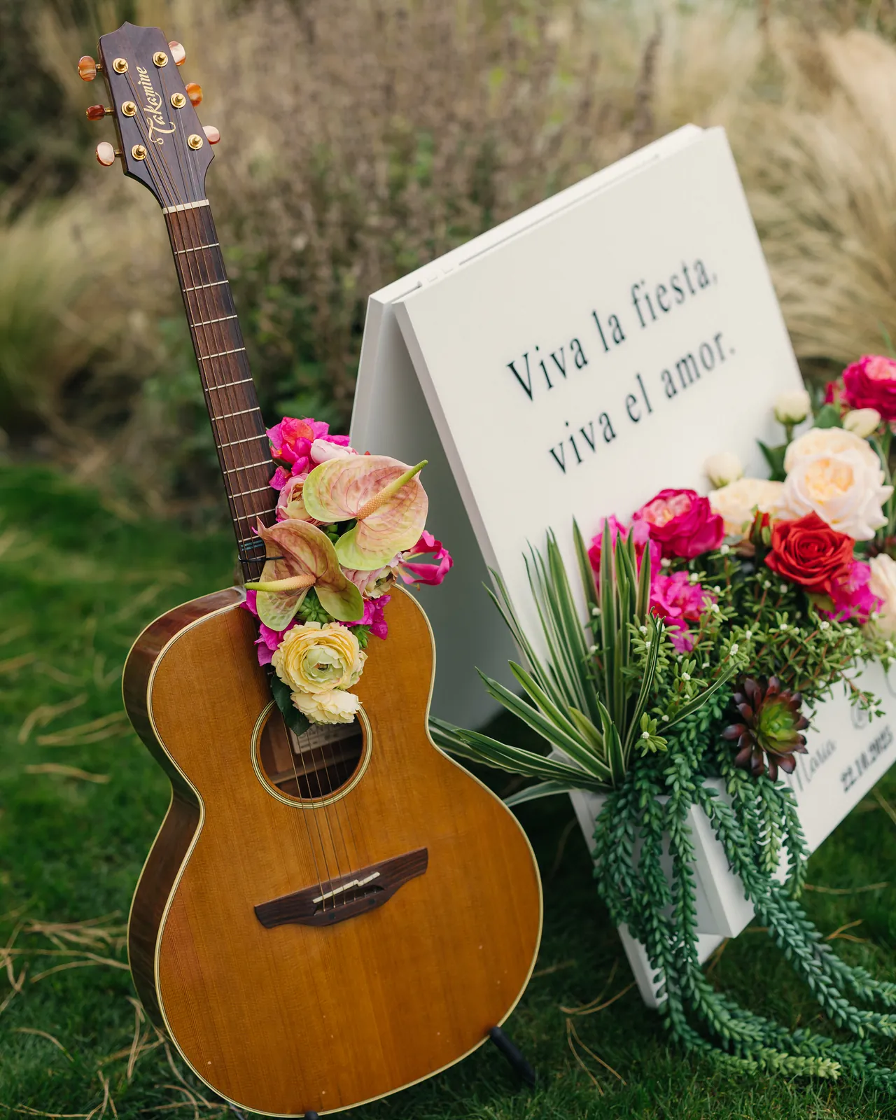 Gitarre mit Blumen neben dem Willkommensschild «Viva la fiesta, viva el amor»