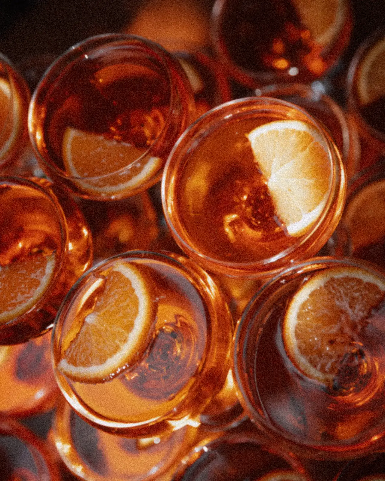 Aperol in Coupe-Gläsern mit Orangenscheiben, von oben fotografiert