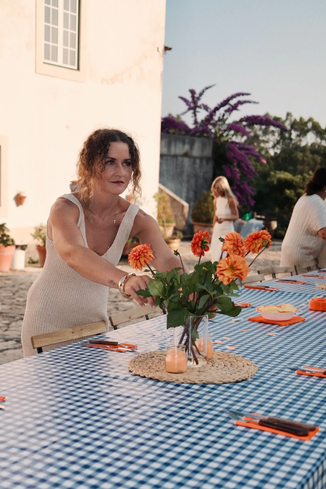 Andrea stellt Blumen auf die Tafel vor einem Landhaus in Portugal
