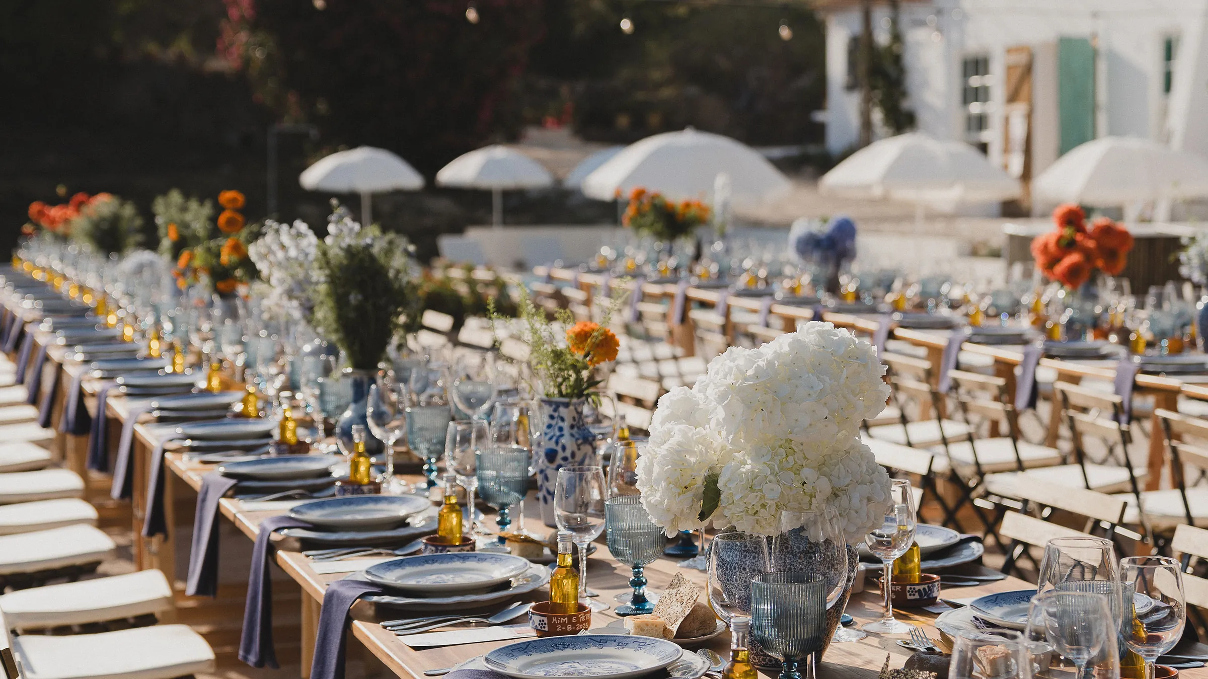 Lange festlich gedeckte Hochzeitstafel unter Lichterketten in Portugal