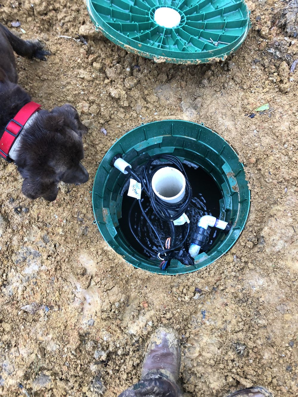 An open septic pump tank showing floats and plumbing during a Holmes Septic service call