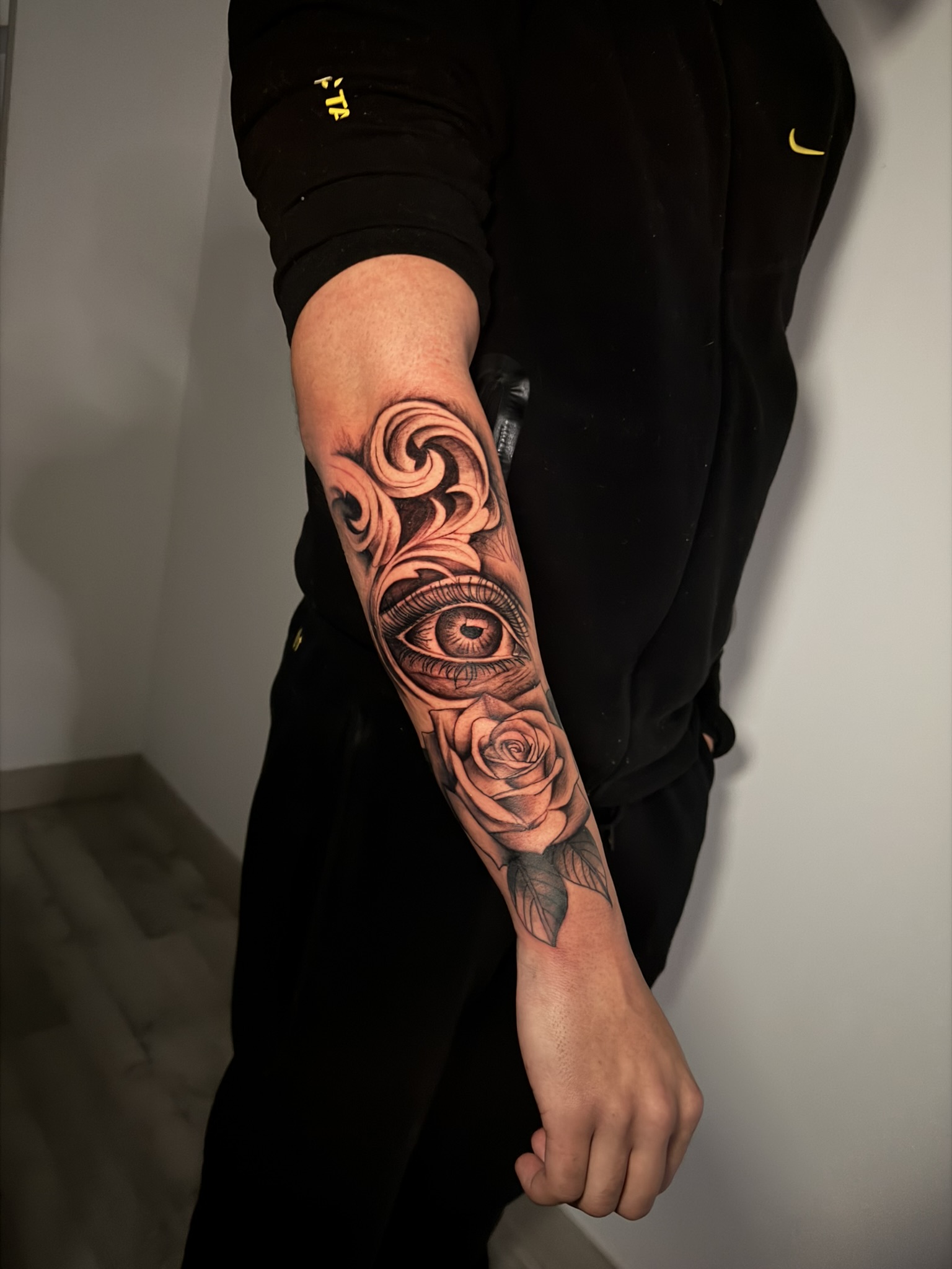Tatuaje black and grey — retrato chicano con maquillaje payaso y texto Hustle, obra de Rober INK