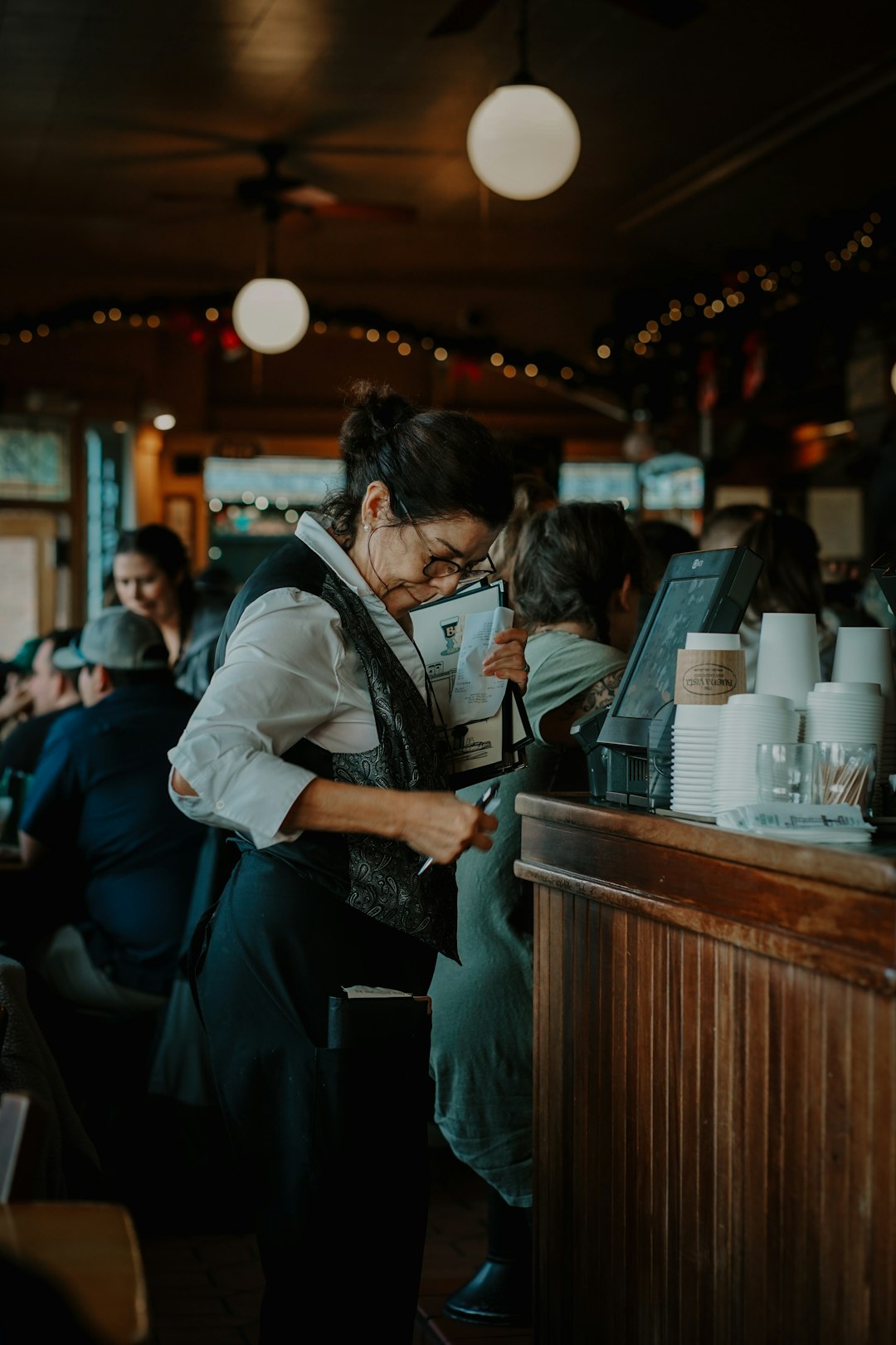server at restaurant processing check in pos system