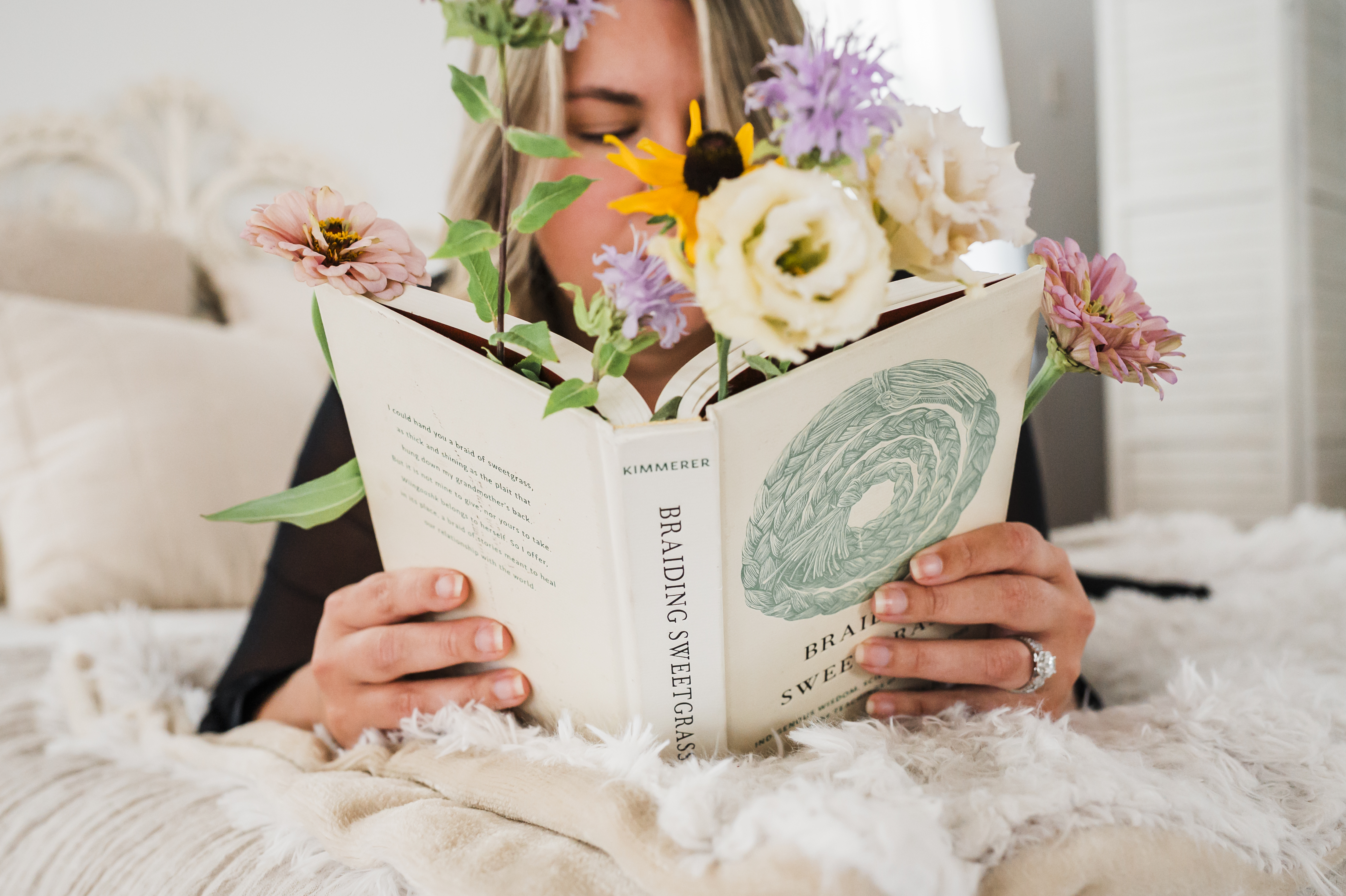 Nicole reading in a wildflower field